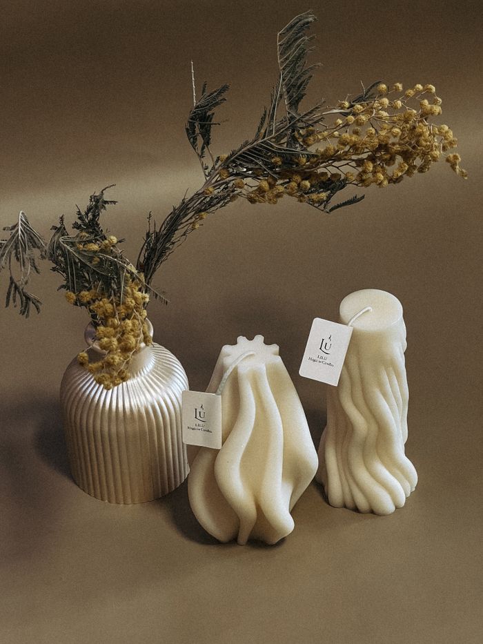 Elegant sculpted candles set with dried flowers in a minimalist style, perfect for cozy decor.